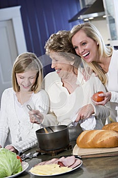 Grandmother with family cooking in kitchen