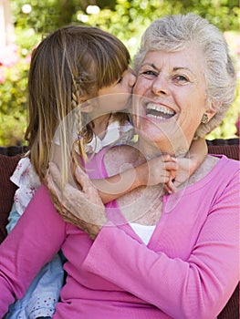 Grandmother getting a kiss from granddaughter