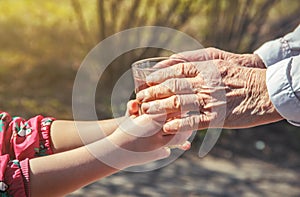 Grandmother giving a glass of clean water to a child.