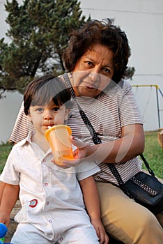 Grandmother giving water to her grandson