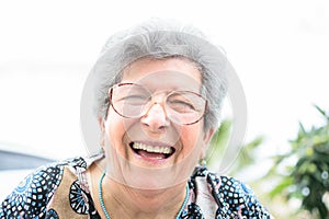 Grandmother with glasses and gray hair very happy smiling with denture