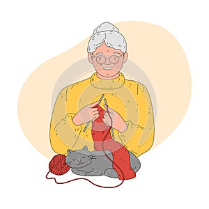 Grandmother in glasses knitting warm red scarf for child with cat relaxing nearby