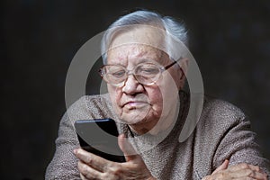 Grandmother with glasses looking at smartphone