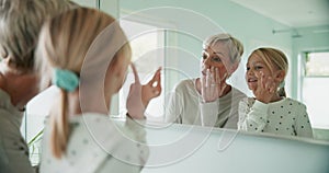 Grandmother, grandchild and mirror, skincare and cream on face with morning routine in bathroom and bonding. Self care