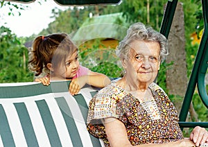 Grandmother with grandchild - senior woman looking at her granddaughter outdoor in nature