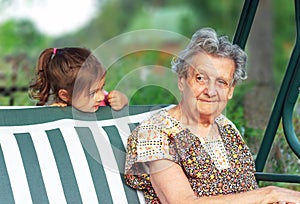 Grandmother with grandchild - senior woman taking and smiling with her granddaughter outdoor