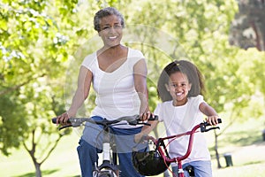 Grandmother and granddaughter on bikes outdoors