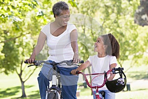 Grandmother and granddaughter on bikes outdoors