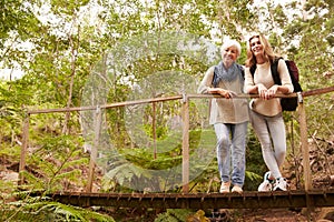 Grandmother and granddaughter on a bridge in a forest