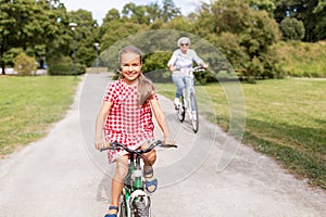 Grandmother and granddaughter cycling at park