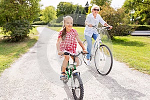 Grandmother and granddaughter cycling at park