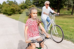 Grandmother and granddaughter cycling at park