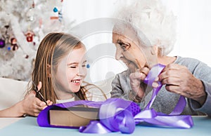 Grandmother with granddaughter decorating gifts