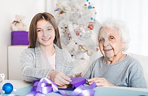 Grandmother with granddaughter decorating gifts