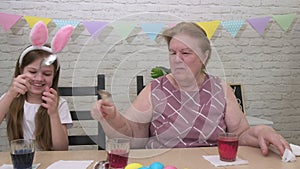 Grandmother granddaughter fight with spoons while preparing for easter