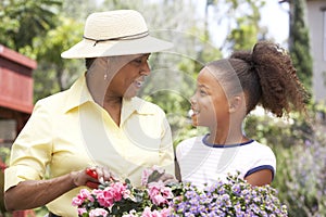 Grandmother With Granddaughter Gardening Together