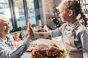 grandmother and granddaughter giving high five on thanksgiving after successful