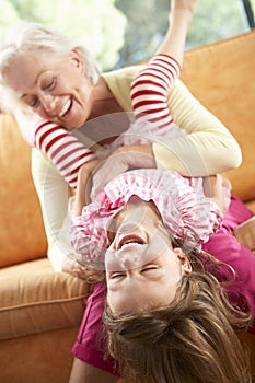 Grandmother And Granddaughter Having Fun On Sofa
