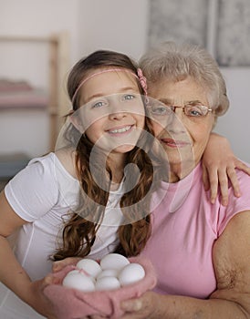 Grandmother with granddaughter are holding Easter eggs
