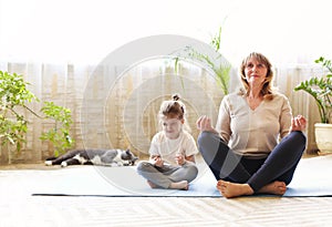 Grandmother and granddaughter meditating together