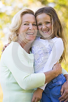 Grandmother and granddaughter outdoors and smiling