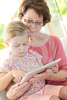 Grandmother and granddaughter playing on a tablet