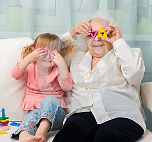 Grandmother with granddaughter playing toys