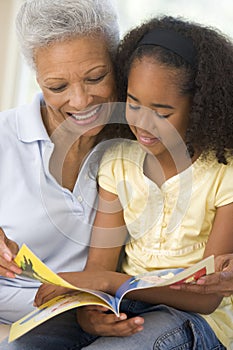 Grandmother and granddaughter reading and smiling