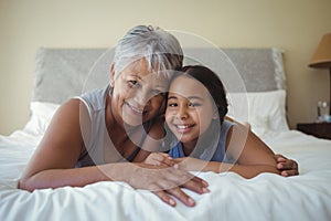Grandmother and granddaughter relaxing on bed in bed room