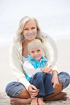 Grandmother And Granddaughter Sitting On Beach