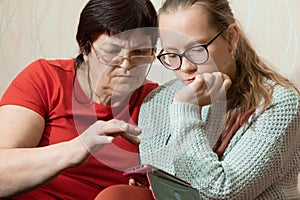 Grandmother with granddaughter and smartphone