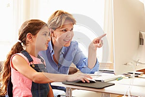 Grandmother And Granddaughter Using Computer At Home