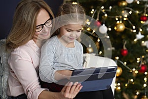 Grandmother with granddaughter using tablet in Christmas time