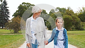 Grandmother and granddaughter walking at park