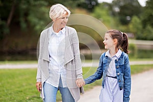 Grandmother and granddaughter walking at park