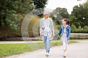 Grandmother and granddaughter walking at park