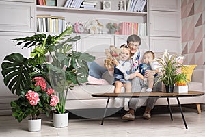 Grandmother with granddaughters on the couch shows a puppet show