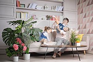 Grandmother with granddaughters in the living room. Baby is upside down