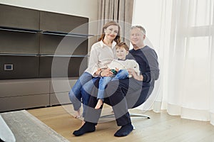 Grandmother and grandfather with grandson in a room in front of