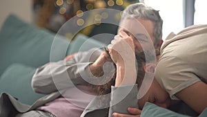 Grandmother and grandson celebrating christmas. Lovely teenage boy with curly hair hugs a stylish gray-haired woman