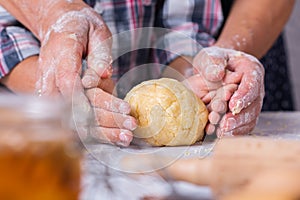 Grandmother with grandson cooking, kneading dough, baking in the kitchen