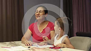 Grandmother with grandson having fun at home talking jokes.