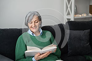 Grandmother in a green sweater reading a book