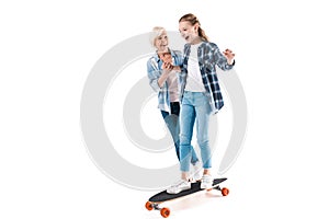Grandmother and happy granddaughter with skateboard