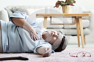 Grandmother with heart attack lying on the floor alone