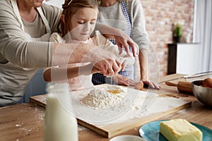 Grandmother helping girl to Easter bake