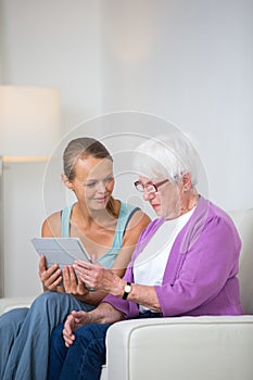 Grandmother with her grand-daughter sitting on a sofa