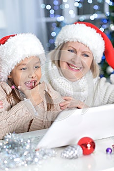 grandmother and her granddaughter using laptop