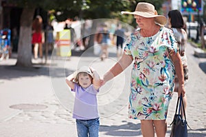 Grandmother and her granddaughter walking in the city, taking time together.