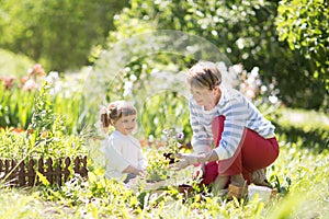 Grandmother with her granddaughter working in the garden.